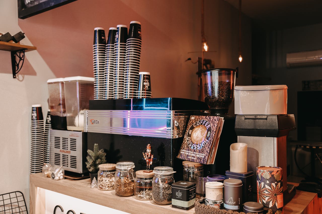 Aesthetic café setup featuring coffee machines, cups, and diverse jars for a relaxing vibe.